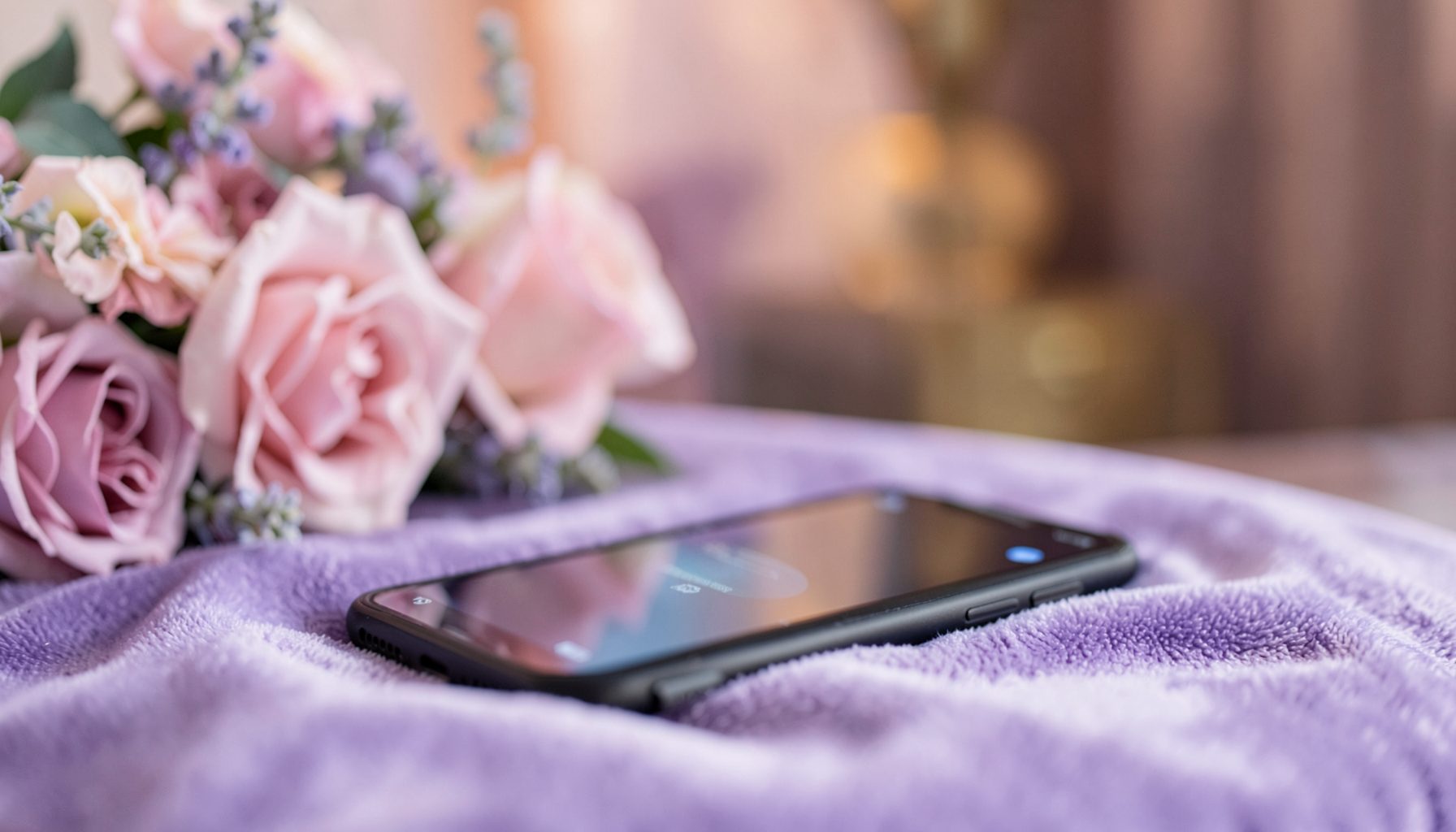 Soft-focus interior with rose and lavender tones, a smartphone lying on a plush velvet surface